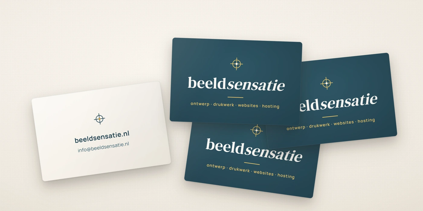 Vier visitekaartjes van Beeldsensatie op een tafel: drie petrol voorkanten met het beeldmerk, het woordmerk beeldsensatie en de diensten ontwerp, drukwerk, websites en hosting, plus een lichte achterkant met het webadres en e-mailadres.